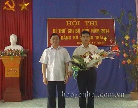 Đồng chí Trần Thế Hùng - Bí thư Huyện ủy Văn Yên tặng hoa chúc mừng thí sinh tham gia Hội thi Bí thư chi bộ giỏi năm 2014 tại xã Yên Thái.
