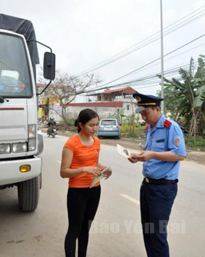 Cán bộ thanh tra giao thông kiểm tra hành chính phương tiện vận tải hàng hóa.
