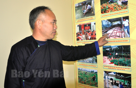 Ông Sùng A Khua tham quan triển lãm hình ảnh về các mô hình kinh tế hiệu quả ở vùng nông thôn.