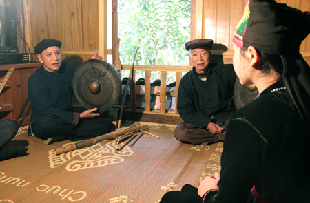 Nghệ nhân Vì Văn Sang (trái) hướng dẫn thế hệ trẻ đánh cồng chiêng của dân tộc Khơ Mú.