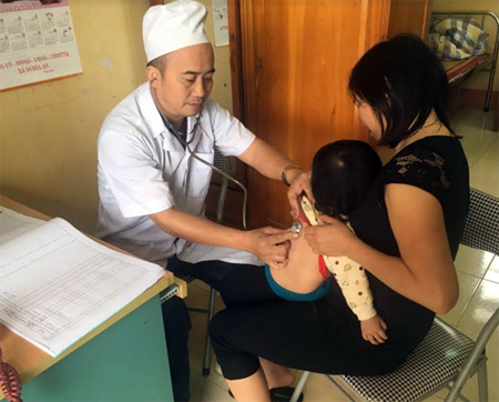 Y sỹ Nguyễn Ngọc Thăng thăm khám bệnh cho trẻ em.