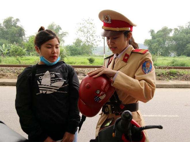 Cán bộ Đội Cảnh sát giao thông, trật tự, Công an huyện Trấn Yên tuyên truyền, hướng dẫn người dân về cách phân biệt mũ bảo hiểm đạt chuẩn và không đạt chuẩn.