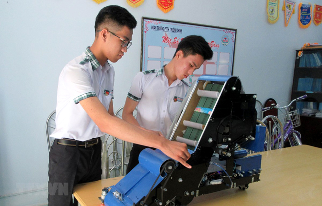 Nguyễn Hữu Thực và Trần Hoàng Nguyên với mô hình máy điều khiển tự động thu gom nông sản.