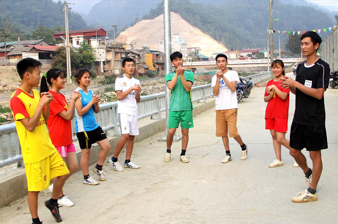 Cán bộ Trung tâm Truyền thông và Văn hóa huyện Mù Cang Chải hướng dẫn học sinh các bước khởi động trước khi tham gia hoạt động thể thao.