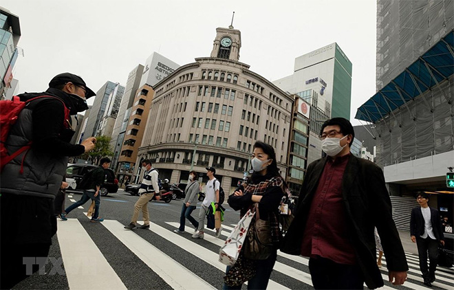 Người dân đeo khẩu trang để phòng tránh lây nhiễm COVID-19 tại Tokyo, Nhật Bản, ngày 28/3/2020.