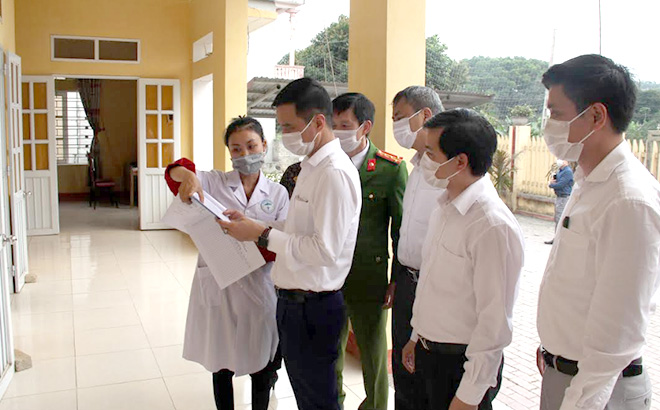 Đồng chí Dương Văn Tiến - Phó Chủ tịch UBND tỉnh kiểm tra sổ ghi chép khám, chữa bệnh tại xã Đại Minh, huyện Yên Bình.