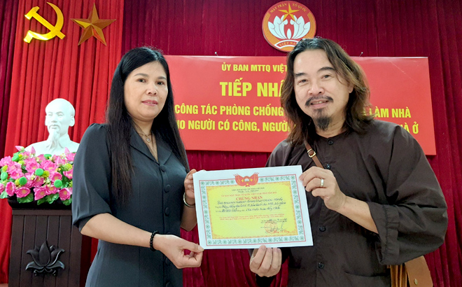 Nguyen Thi Bich Nhiem, Vice Chairwoman of the provincial Fatherland Front Committee, presents a certificate of William Hubert’s donation to Nguyen Quang Truong on April 20 morning.