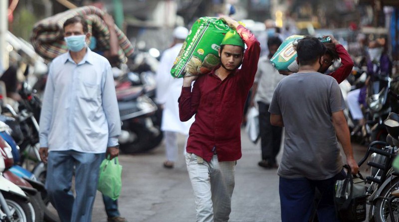 Người dân đi mua đồ thiết yếu tại khu Dharavi - khu ổ chuột lớn nhất thế giới tại thành phố Mumbai.