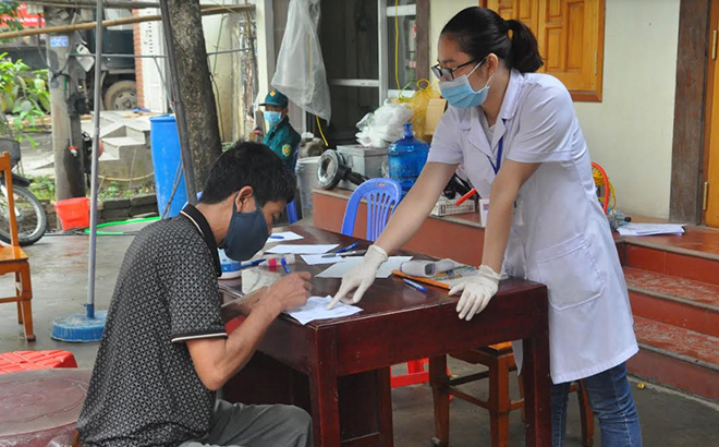 Cán bộ y tế hướng dẫn người dân khai báo y tế tại chốt kiểm dịch số 3, Km 14, thị trấn Yên Bình, huyện Yên Bình.