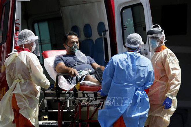 Nhân viên y tế chuyển bệnh nhân COVID-19 từ xe cứu thương vào một bệnh viện ở Brasilia, Brazil ngày 25/3/2021