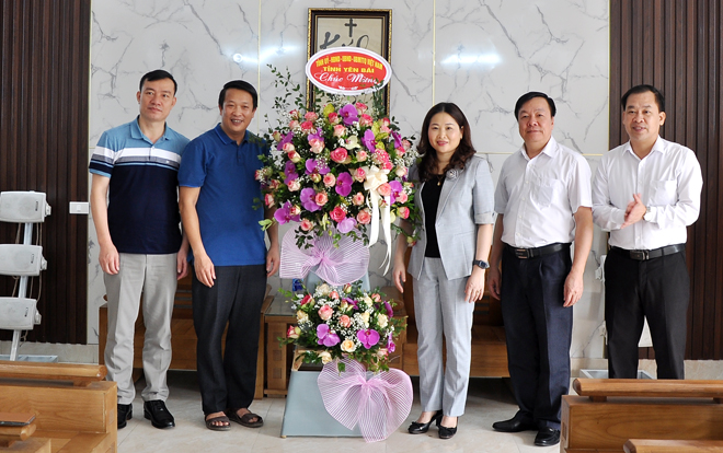 Thay mặt lãnh đạo tỉnh, đồng chí Vũ Thị Hiền Hạnh - Phó Chủ tịch UBND tỉnh tặng hoa chúc mừng Hội đồng Giáo xứ Mông Sơn.