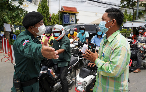 Cảnh sát Campuchia chặn người lái xe máy tại một chốt kiểm soát dịch ở thủ đô Phnom Penh ngày 16-4