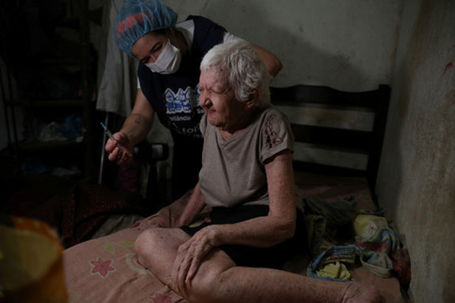 Bà Elisa Melo Marinho, 86 tuổi, được tiêm vắc-xin Covid-19 của AstraZeneca tại nhà ở khu ổ chuột Rocinha thuộc TP Rio de Janeiro - Brazil.