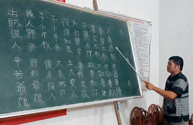 Ông Triệu Quý Tín đang truyền dạy ngôn ngữ, chữ viết dân tộc Dao quần chẹt.