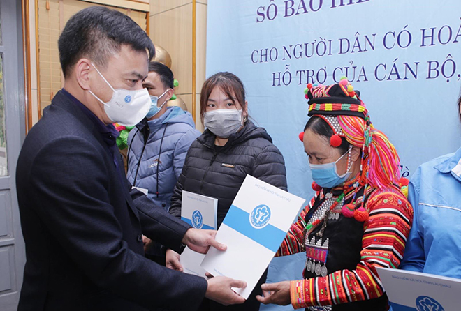 Phó Giám đốc BHXH tỉnh Lai Châu, Dương Quốc Tuấn trao sổ BHXH và thẻ BHYT cho các hộ dân nghèo có hoàn cảnh đặc biệt khó khăn của huyện biên giới Mường Tè (Lai Châu).