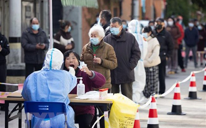 Nhân viên y tế lấy mẫu xét nghiệm COVID-19 cho người dân ở TP Thượng Hải, Trung Quốc ngày 1/4/2022.