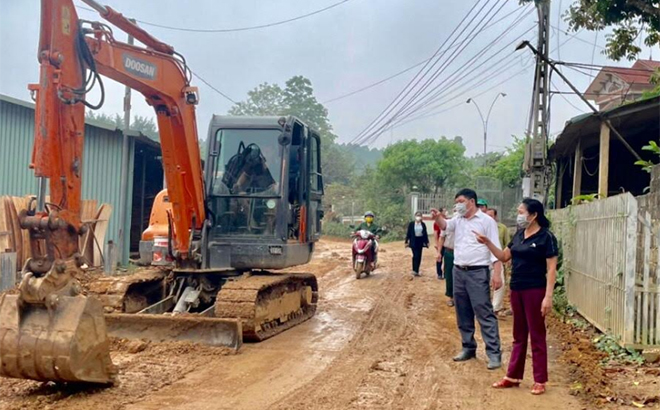 Chị Nguyễn Thị Thu cùng lãnh đạo thôn Mạ kiểm tra, giám sát thi công mở rộng hành lang tuyến đường từ Thác Ông chạy qua trung tâm thôn.