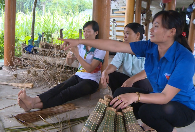 Bí thư Chi bộ Tăng Thị Đàm (ngoài cùng bên phải) trao đổi công việc với xã viên HTX đan rọ tôm.