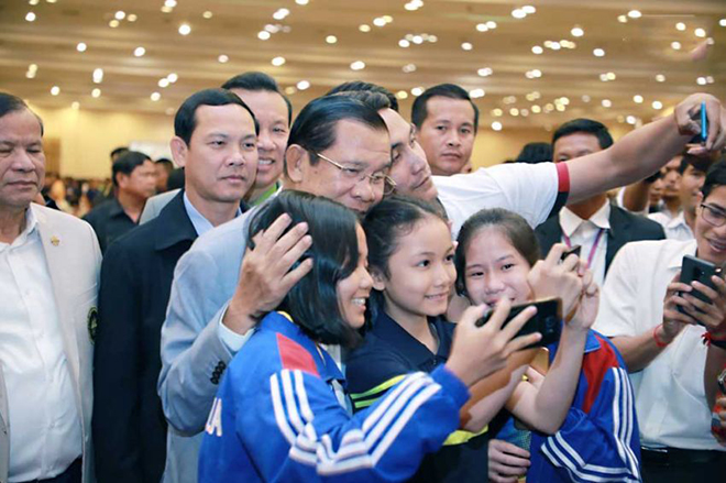 Thủ tướng Hun Sen (đeo kính, trái) chụp hình lưu niệm với một số thành viên Đoàn thể thao Campuchia.