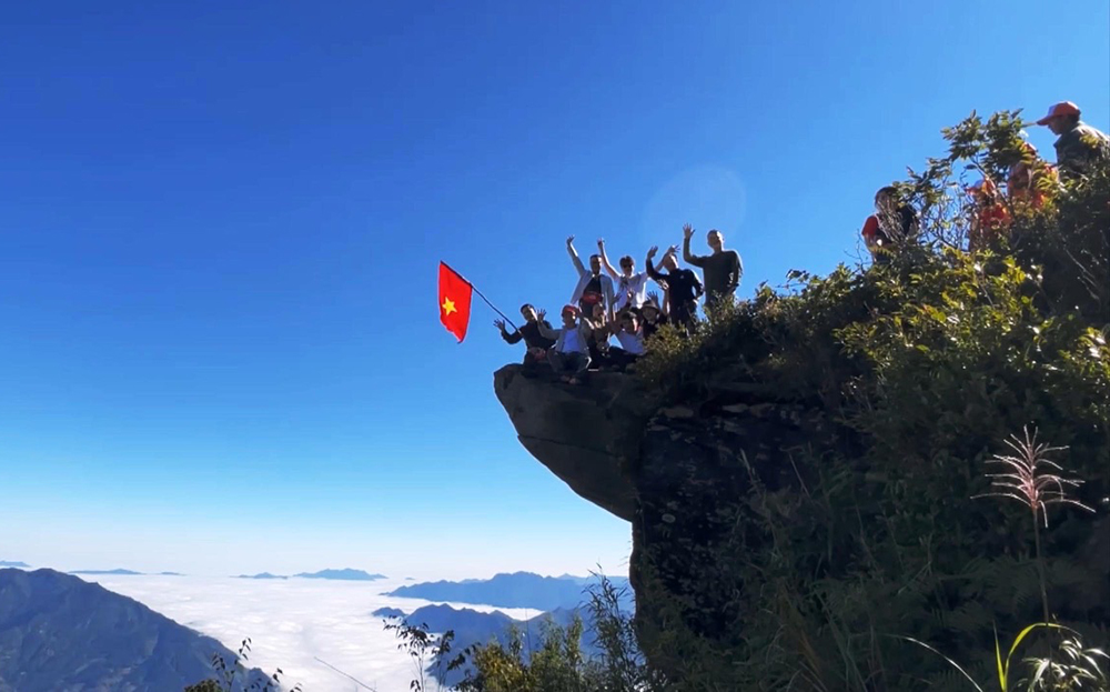 Du khách săn mây, chụp ảnh ở mỏm đá đầu rùa trên đỉnh núi Tà Xùa, xã Bản Công, huyện Trạm Tấu.