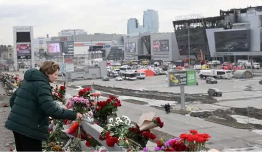 Một phụ nữ ở Krasnogorsk - Nga đặt hoa tưởng niệm các nạn nhân trong vụ khủng bố ở gần Moscow hôm 26-3.