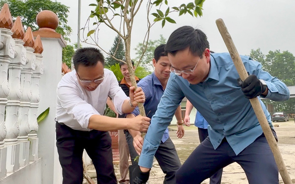 Bí thư Huyện ủy Yên Bình An Hoàng Linh và Linh mục Giáo xứ Bảo Ái tham gia trồng cây xanh quanh khuôn viên nhà thờ.