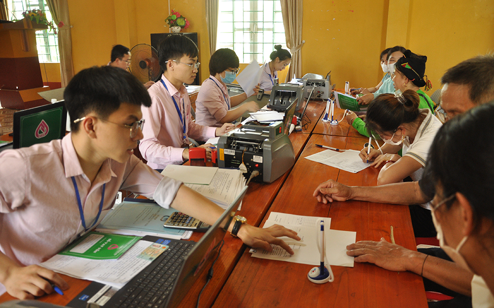 Cán bộ Phòng giao dịch Ngân hàng Chính sách Xã hội huyện Lục Yên giải ngân nguồn vốn vay hỗ trợ xuất khẩu lao động.