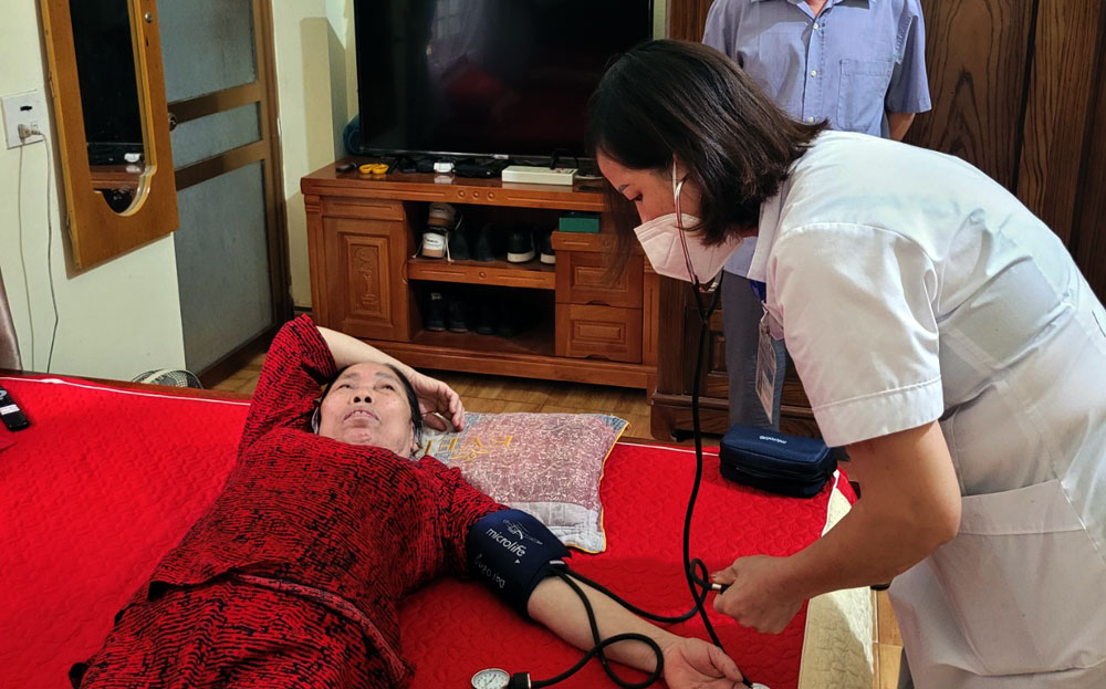 Cán bộ Trạm Y tế xã Đại Đồng, huyện Yên Bình kiểm tra sức khỏe cho bệnh nhân tại nhà.