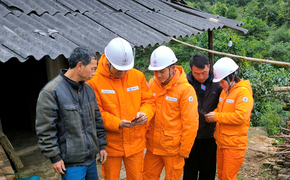 Công nhân Công ty Điện lực Yên Bái hướng dẫn khách hàng thanh toán tiền điện không dùng tiền mặt 