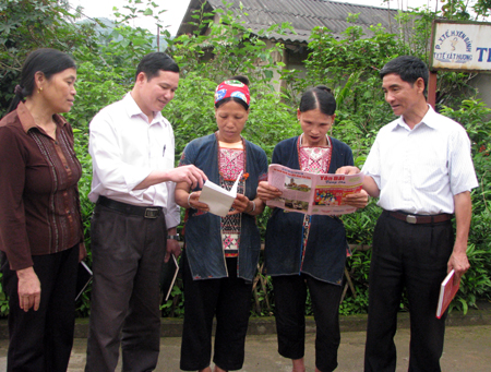 Cử tri dân tộc Dao xã Tân Hương (Yên Bình) tìm hiểu luật bầu cử tìm hiểu thông tin bầu cử trog mục “Hỏi đáp về bầu cử trên ấn phẩm báo Yên Bái vùng cao. (Ảnh: Q.N)