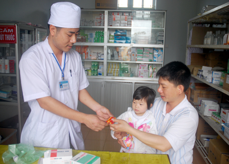 Cán bộ phòng khám đa khoa khu vực Thác Bà (Yên Bình) cấp thuốc cho bệnh nhân BHYT.
