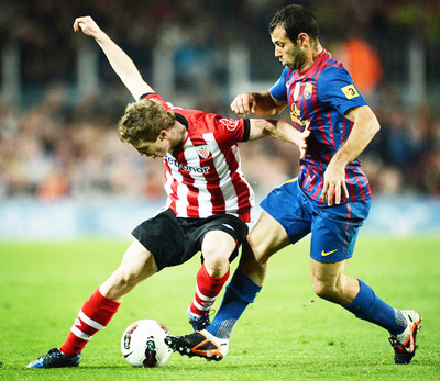 Iker Muniain (trái, Bilbao) kiểm soát bóng trước Javier Mascherano (Barcelona).