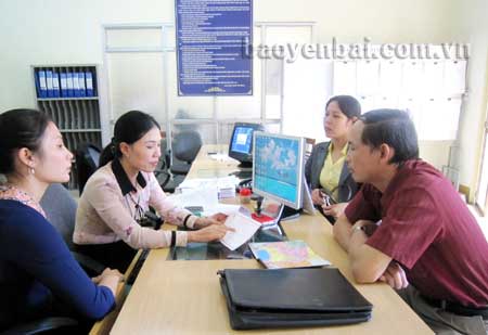 Cán bộ chi cục thuế huyện Yên Bình hướng dẫn người nộp thuế kê khai đăng ký thuế tại bộ phận giao dịch “một cửa”.
