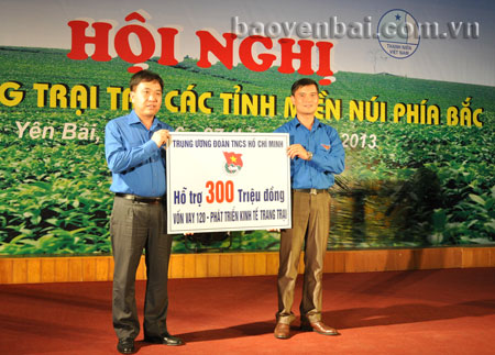 Đồng chí Nguyễn Phi Long - Phó chủ tịch Thường trực Hội Liên hiệp thanh niên Việt Nam (trái) trao 300 triệu đồng hỗ trợ từ nguồn vốn vay 120 - phát triển kinh tế trang trại cho Tỉnh đoàn Yên Bái.