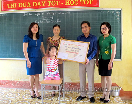 Lãnh đạo Công ty Cổ phần dinh dưỡng Việt Tín trao tặng học bổng cho bé Linh Chi trước sự chứng kiến của Ban Giám hiệu Trường Tiểu học Nguyễn Thái Học.