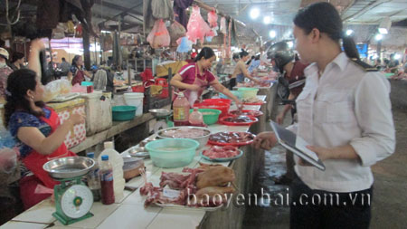 Cán bộ thú y kiểm tra sản phẩm  thịt chó tại chợ Yên Thịnh (thành phố Yên Bái).