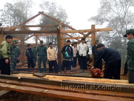 Cán bộ, chiến sỹ lực lượng vũ trang huyện Trạm Tấu giúp người dân thôn Tà Chử, xã Bản Công dựng nhà mới.
