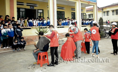 Đội tình nguyện viên chữ thập đỏ cắt tóc cho các em học sinh Trường THCS Dân tộc nội trú huyện Trấn Yên.