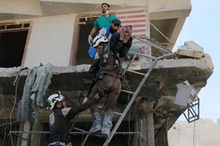 Các tình nguyện viên ở Syria cứu người dân ra khỏi một tòa nhà đổ nát tại Aleppo. Ảnh: AFP