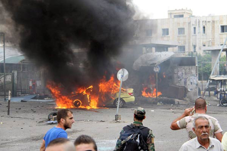 Một chiếc xe cháy tại hiện trường một vụ đánh bom tự sát tại TP Tartus, Syria, ngày 23-5-2016.