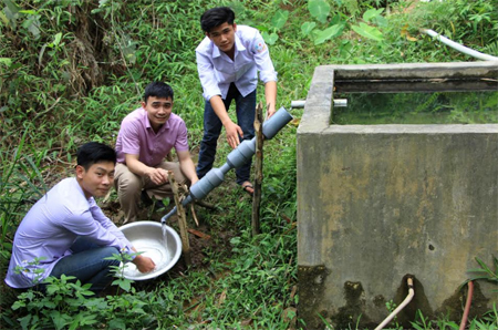 Em Hoàng Văn Cường, Hà Văn Mười và thầy giáo Nguyễn Văn Đức lắp đặt ống lọc nước tại nhà dân.