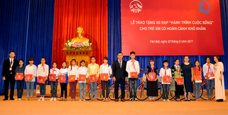 Đại diện AIA và lãnh đạo Sở Lao động - Thương binh và Xã hội tỉnh trao quà và xe đạp cho 30 trẻ em nghèo có hoàn cảnh khó khăn của tỉnh Yên Bái.