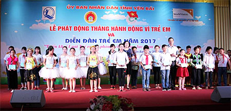 Đồng chí Dương Văn Tiến - Phó Chủ tịch UBND tỉnh (bên phải) trao học bổng cho các em học sinh có hoàn cảnh khó khăn.