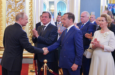 Tổng thống Putin bắt tay Thủ tướng Dmitry Medvedev trước sự chứng kiến của cựu Thủ tướng Đức Gerhard Schroeder (giữa) sau khi tuyên thệ nhậm chức ngày 7/5.