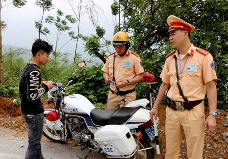 Lực lượng CSGT Công an huyện Văn Chấn kiểm tra giấy tờ của người điều khiển phương tiện tham gia giao thông.
