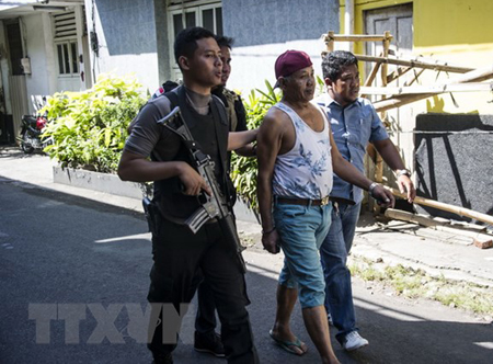 Cảnh sát bắt giữ một đối tượng tình nghi để thẩm vấn sau vụ tấn công ở Surabaya, Indonesia ngày 14/5 vừa qua.