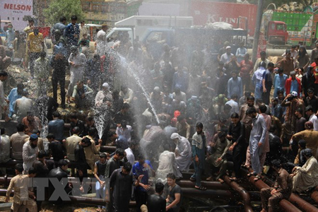 Người dân giải nhiệt tại hệ thống ống cấp nước ở Karachi, Pakistan ngày 22-5.