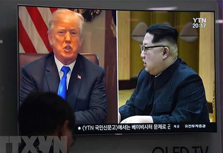 Người dân theo dõi qua truyền hình hình ảnh Tổng thống Mỹ Donald Trump (trái) và Nhà lãnh đạo Triều Tiên Kim Jong-un.