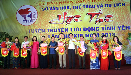 Đồng chí Dương Văn Tiến – Phó Chủ tịch UBND tỉnh cùng Ban tổ chức Hội thi Tuyên truyền lưu động tỉnh Yên Bái năm 2018 trao cờ lưu niệm cho các đội tham gia.