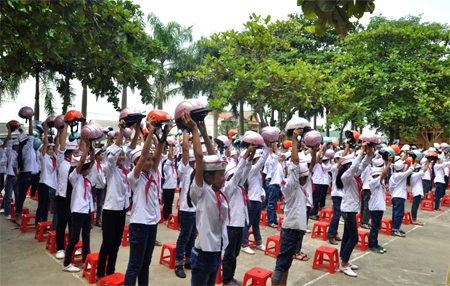 Hướng dẫn học sinh đội mũ bảo hiểm đúng cách được nhiều trường học triển khai thường xuyên tại các giờ chào cờ.